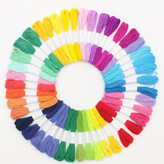 Madejas de hilo Mouliné en 50 colores diferentes dispuestas en círculo sobre fondo blanco, ideales para bordado y punto de cruz