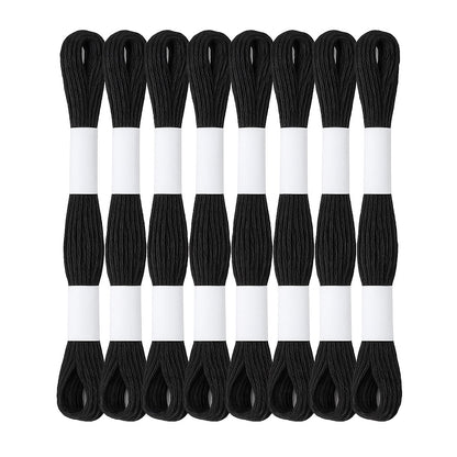 Madejas de hilo Mouliné en color negro dispuestas en semicírculo con etiquetas blancas sobre fondo blanco, ideales para bordado y proyectos artesanales.